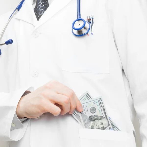 Doctor putting money into his pocket - 1 to 1 ratio — Stock Photo, Image