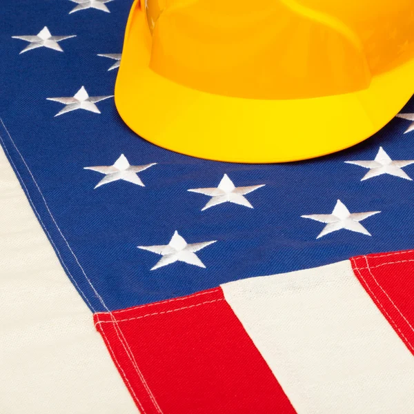 Construction helmet laying over US flag - closeup shoot - 1 to 1 ratio — Stock Photo, Image