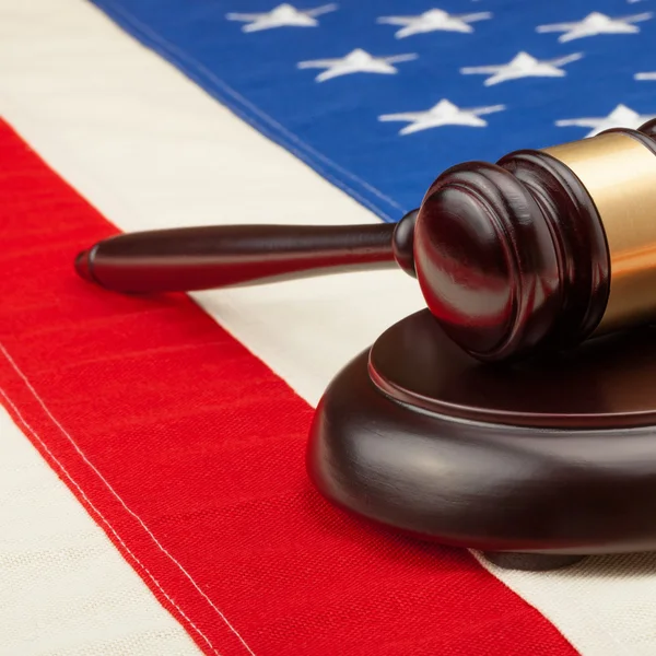 Wooden judge gavel and soundboard laying over USA flag - 1 to 1 ratio — Stock Photo, Image