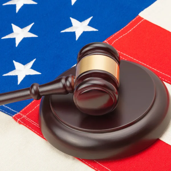 Wooden judge gavel and soundboard laying over USA flag - 1 to 1 ratio — Stock Photo, Image