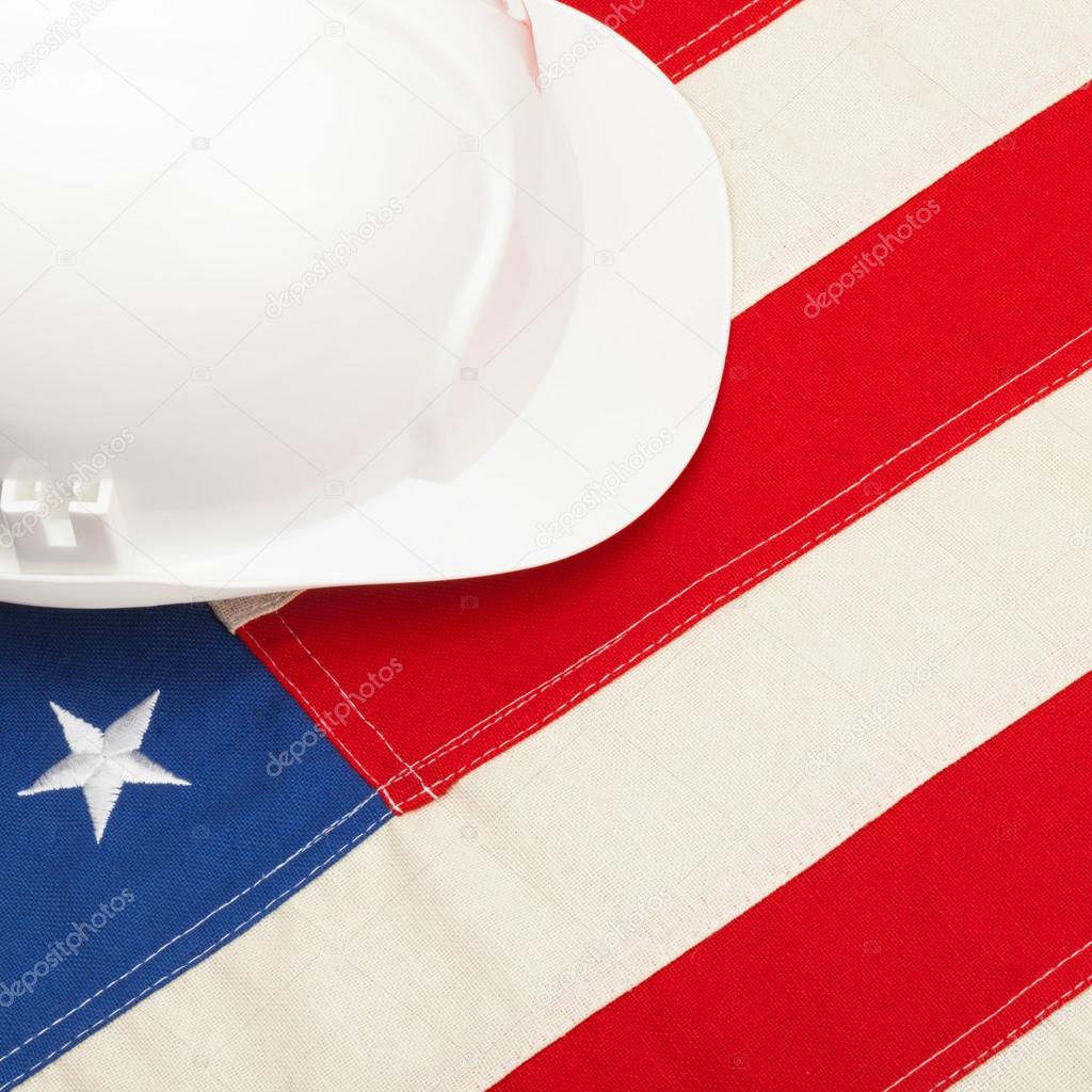 White color construction helmet laying over US flag - 1 to 1 ratio