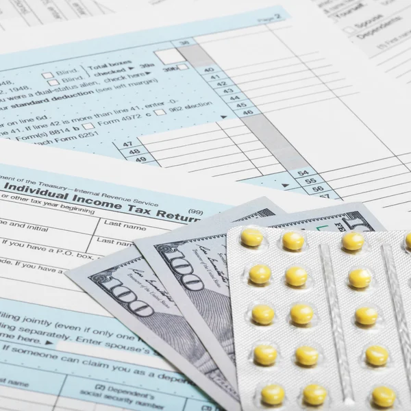US Tax Form 1040 with 100 dollars and pills - 1 to 1 ratio — Stock Photo, Image