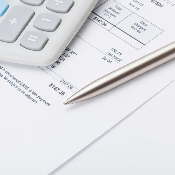 Calculator and pen over some receipt - 1 to 1 ratio — Stock Photo, Image