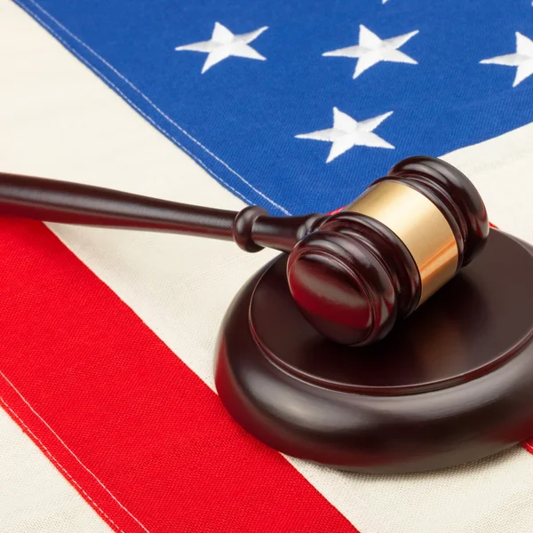 Wooden judge gavel and soundboard over big USA flag - 1 to 1 ratio — Stock Photo, Image