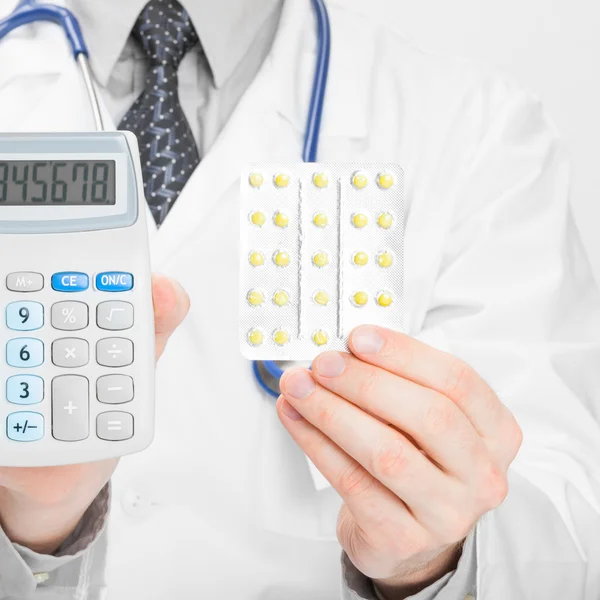 Doctor with calculator and pills in hands - 1 to 1 ratio — Stock Photo, Image