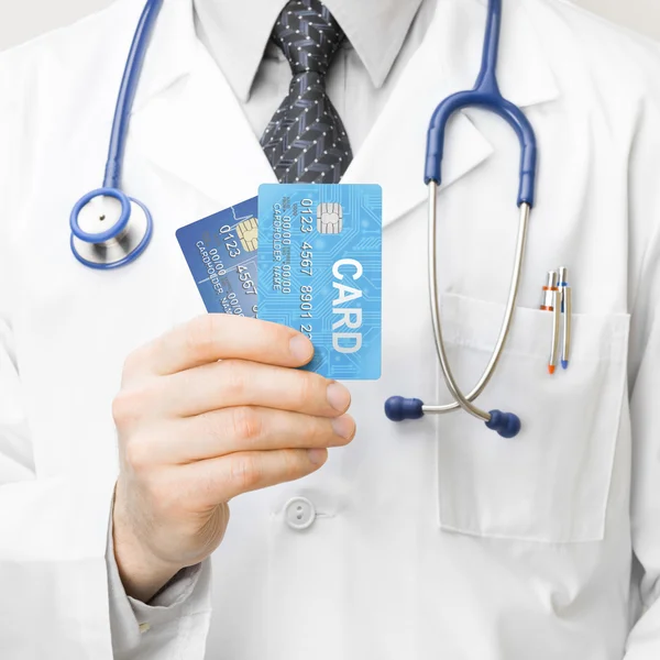 Doctor holding credit cards - 1 to 1 ratio — Stock Photo, Image