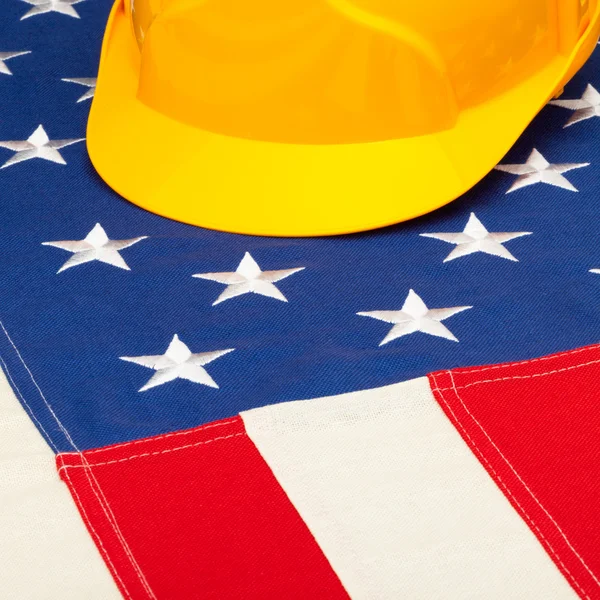 Yellow protective helmet over US flag - closeup shoot - 1 to 1 ratio — Stock Photo, Image