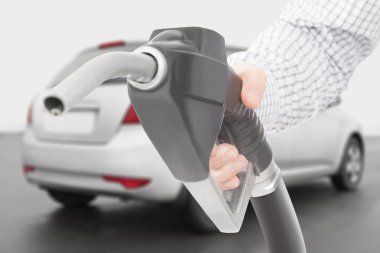 Black color fuel pump gun in hand with car on background clipart