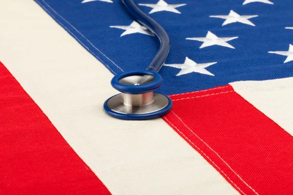 Bandera USA con estetoscopio sobre él - concepto de cuidado de salud — Foto de Stock