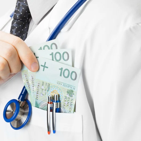 Доктор, помещающий некоторые деньги в его карман — стоковое фото