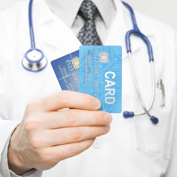 Doctor holding tarjetas de crédito en la mano - closeup studio disparó —  Fotos de Stock