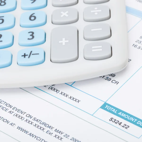 Neat calculator over utility bill - studio shot — Stock Photo, Image