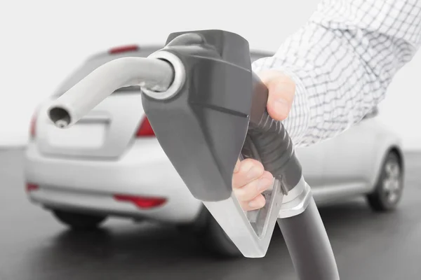 Black color fuel pump gun in hand with car on background — Stock Photo, Image