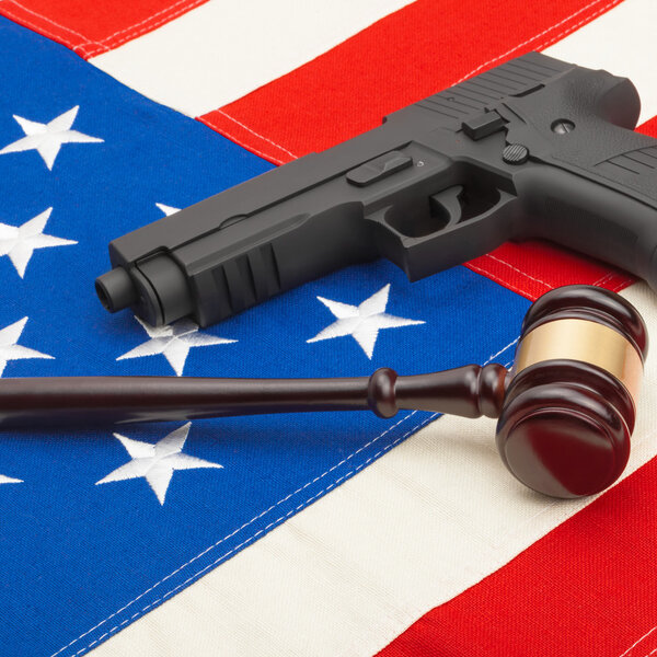 Neat judge gavel and gun over USA flag - studio shoot