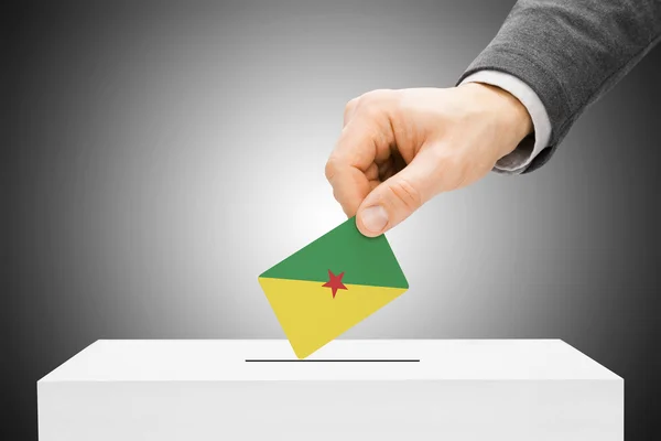 Голосование понятия - мужчины, вставляющего флаг в избирательную урну - Французская Гвиана — стоковое фото