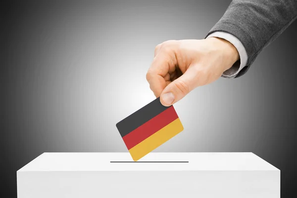Hlasování koncept - mužské vložení příznaku do uren - Německo — Stock fotografie