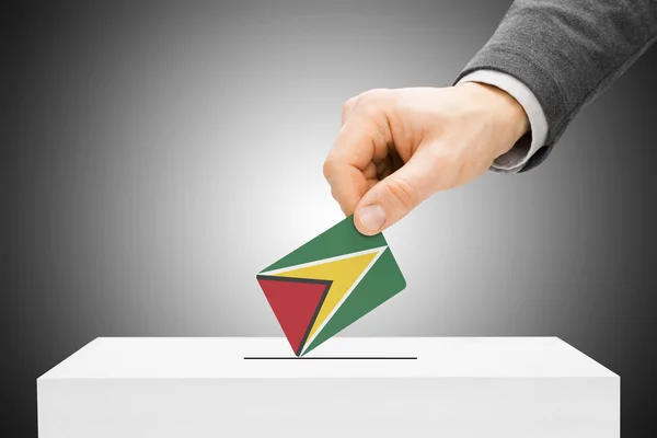 Голосования концепции - мужской вставки флаг в урну - Гайана — стоковое фото