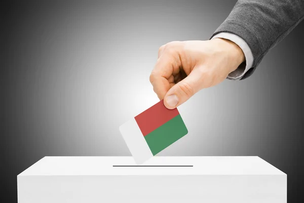 Votação conceito - bandeira inserindo masculino em urnas - Madagascar — Fotografia de Stock