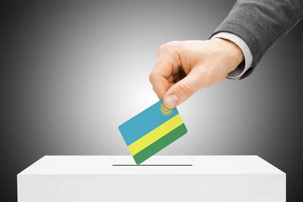 Rösta koncept - manliga infoga flaggan till valurnan - Rwanda — Stockfoto