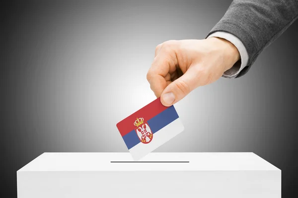 Голосования концепции - мужской вставки флаг в урну - Сербия — стоковое фото