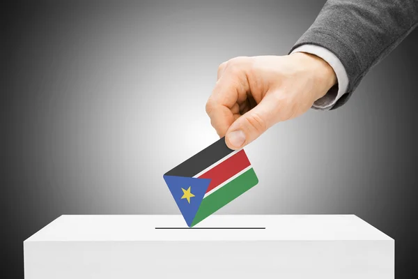 Hlasování koncept - mužské vložení příznaku do uren - Jižní Súdán — Stock fotografie