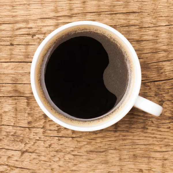 Kaffeetasse auf Holztisch - Ansicht von oben — Stockfoto