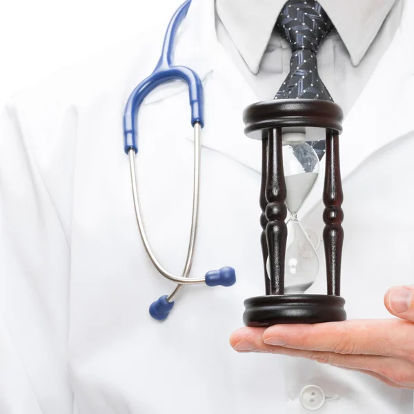 Läkare holdling i hans hand ett timglas - hälso-och koncept — Stockfoto