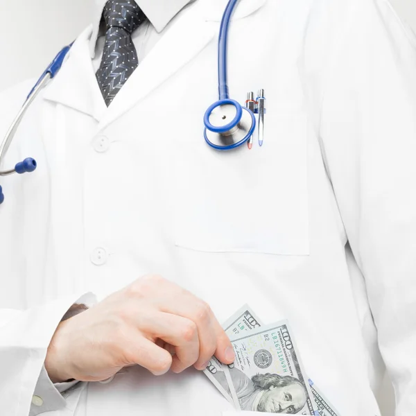 Доктор, помещающий деньги в его карман - понятие здравоохранения — стоковое фото