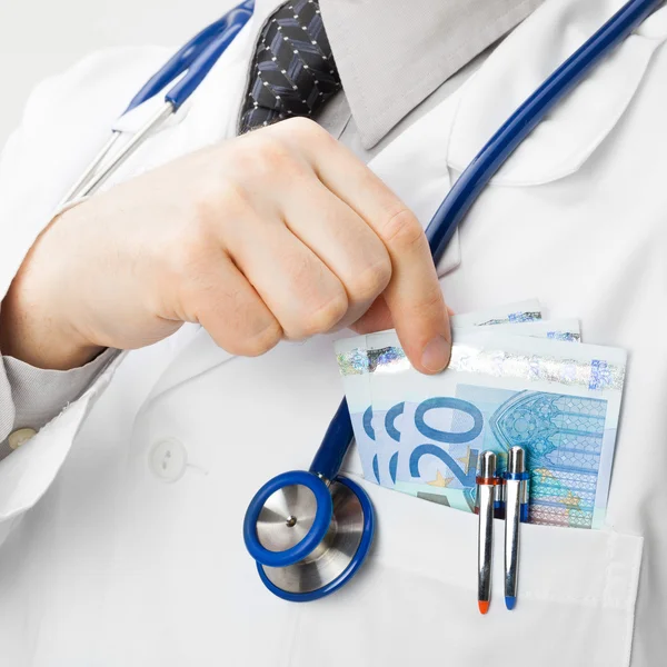 Doctor with money in his pocket - health care concept — Stock Photo, Image