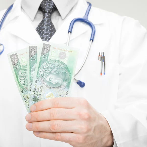 Arts aanhouden van geld in zijn hand - gezondheidszorg concept — Stockfoto