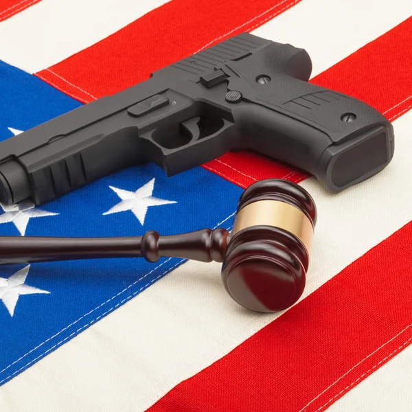 Wooden judge gavel and gun over USA flag - self-defense law concept — Stock Photo, Image