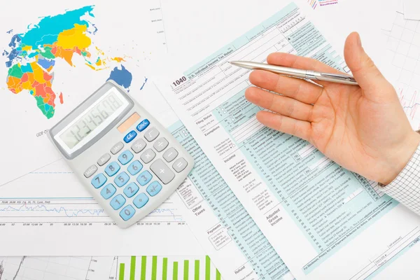 Nás 1040 formulář daňového přiznání, kalkulačka a mužské ruce stříbrem pero v něm — Stock fotografie