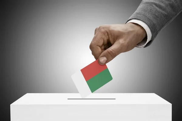 Czarny mężczyzna trzyma flagę. Głosowania koncepcja - Madagaskar — Zdjęcie stockowe