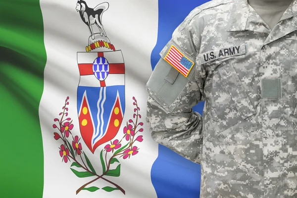 American soldier with Canadian province flag on background - Yukon — kuvapankkivalokuva