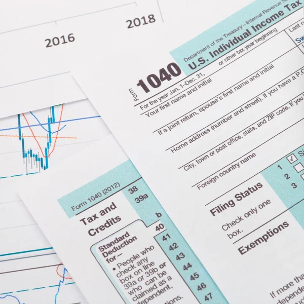 US 1040 Tax Form and calculator over it - studio shot — Stok Foto