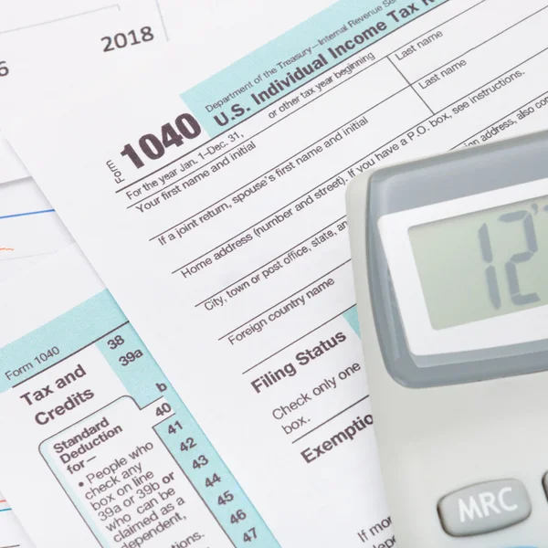 Calculator over US 1040 Tax Form - studio shot — Stock Photo, Image