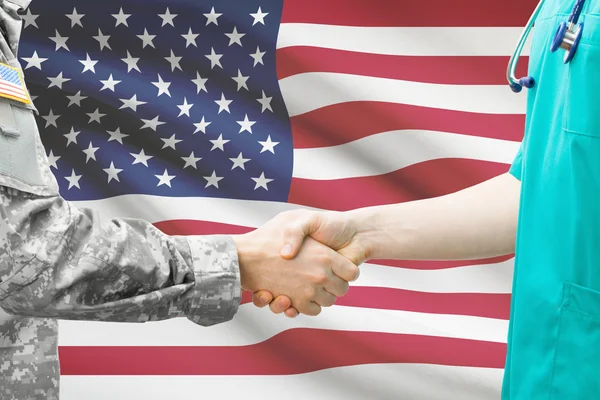 Солдат і лікар, потискує руку прапор на фоні - США — стокове фото
