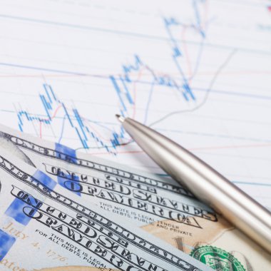 Hisse senedi grafiği üzerinde kalemle yüz ABD Doları