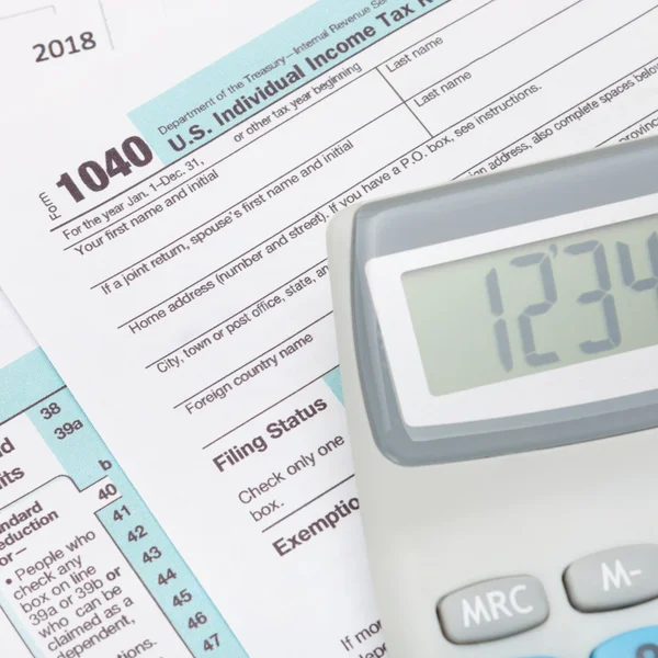 Neat calculator over US 1040 Tax Form — Stock Photo, Image