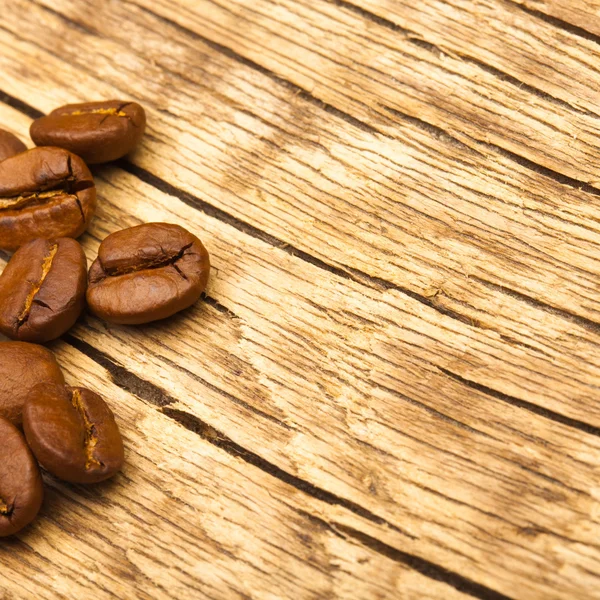 Close up studio shot of roasted coffee beans on old wooden table — Stock Photo, Image