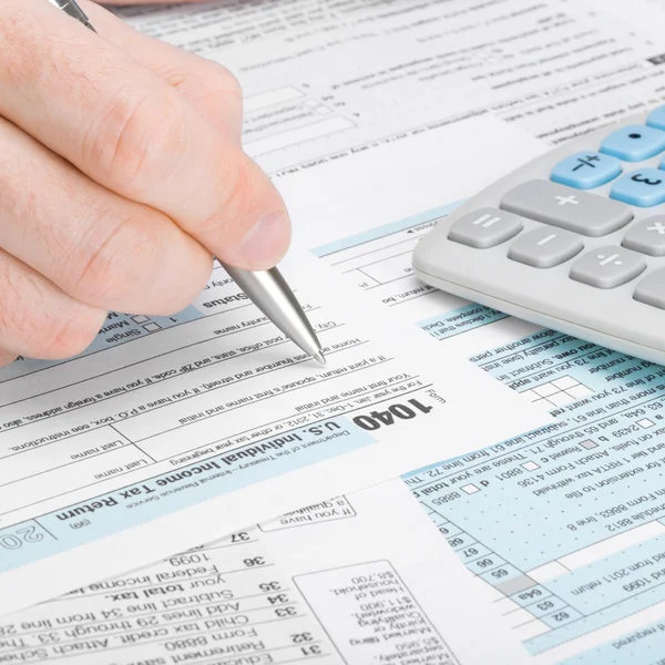 Man filling out 1040 tax form — Stock Photo, Image