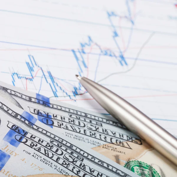 Hundred USA dollars with pen over stock market chart – stockfoto