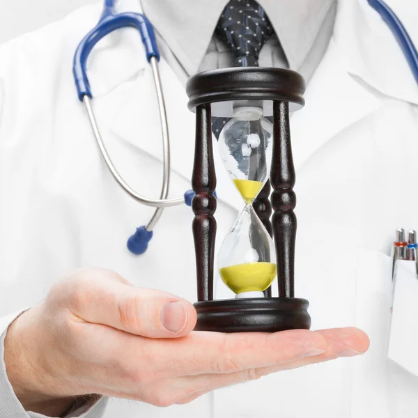 Medical doctor and hourglass - heath care concept — Stock Photo, Image