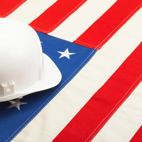 Casco della costruzione di colore bianco sopra la bandiera Stati Uniti d'America — Foto Stock