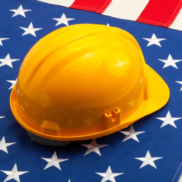 Casco de construcción amarillo sobre bandera de Usa — Foto de Stock