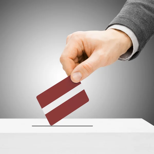 Voto concepto - hombre bandera insertar en urna - Letonia — Foto de Stock