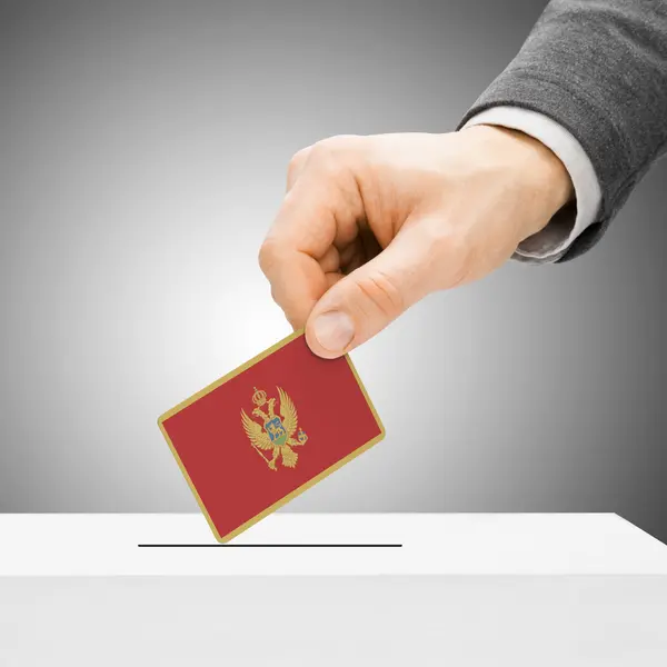 Голосування концепції - чоловіки, вставивши прапор у виборчу скриньку - Montenegr — стокове фото