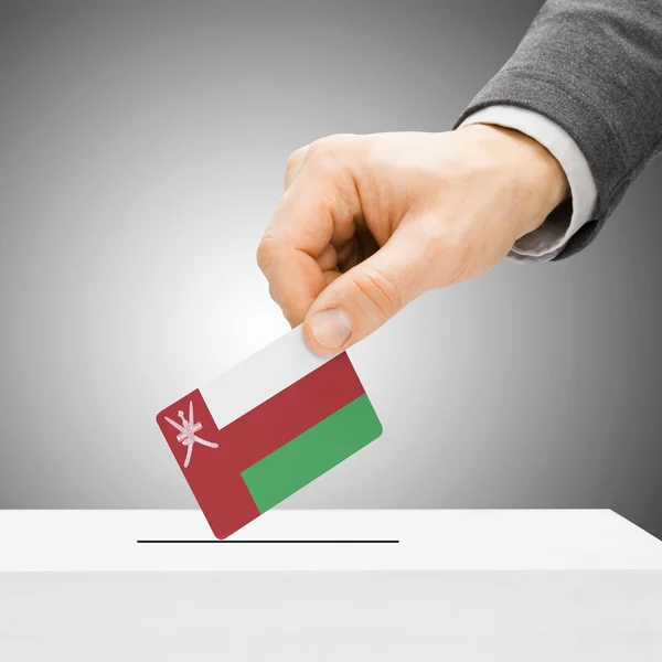 Голосування концепції - чоловічий вставлення прапор в урну - Оман — стокове фото