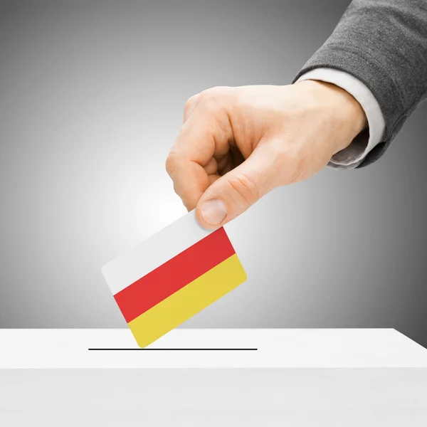 Voting concept - Male inserting flag into ballot box - South Oss — Stock Photo, Image