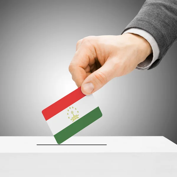 Szavazati koncepció - férfi zászló beszúrásával a szavazólapon doboz - Tajikista — Stock Fotó